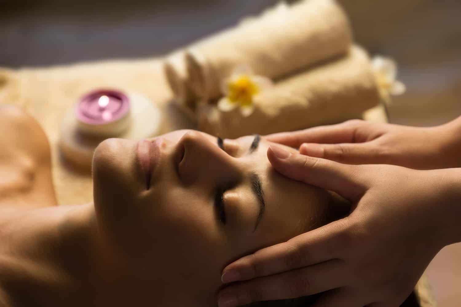 Facial massage, with Domy Beauty with the scent of flowers in the place and a purple stone on her forehead