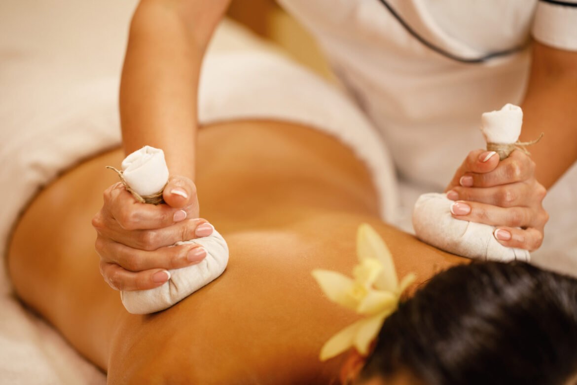 Herbal compress massage therapy as part of the latest spa treatment trends focused on relaxation and muscle comfort in Dubai