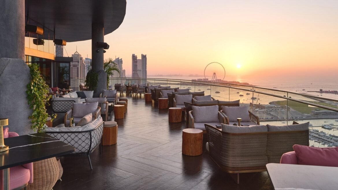 Luxury rooftop dining at sunset overlooking Dubai skyline and Ain Dubai